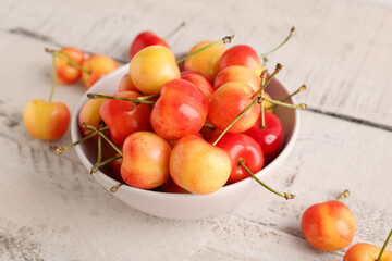 Naklejka na ściany i meble Bowl with sweet yellow cherries on white wooden table