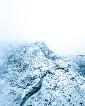Aerial view of the Blue Mountains peak covered with snow and ice during a foggy day in winter, Kopavogur, Iceland.