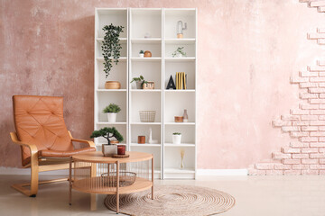Interior of living room with coffee table, brown armchair and shelving unit