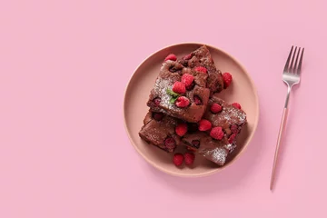Gordijnen Plate with pieces of raspberry chocolate brownie on pink background © Pixel-Shot