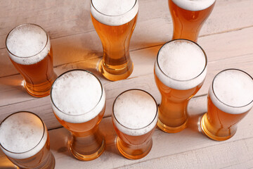 Glasses of cold beer on light wooden background. Oktoberfest celebration
