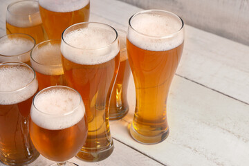 Glasses of cold beer on light wooden background. Oktoberfest celebration