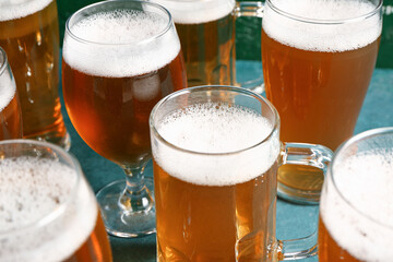 Glasses and mug of cold beer on green background. Oktoberfest celebration
