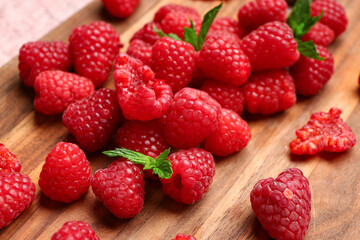 Many fresh raspberries and mint on wooden background