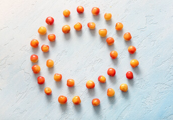 Frame made of sweet yellow cherries on light blue background