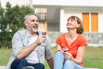 Caucasian senior man and woman having a picnic outdoors in the garden. 