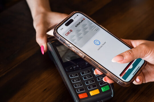 Closeup person paying for purchase with Apple Pay on mobile phone