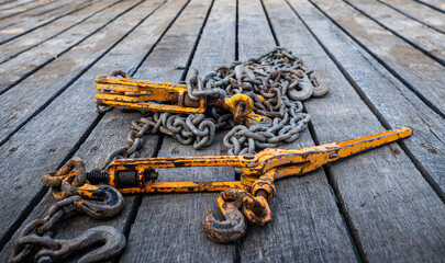 Two old, used and rusty tie down chains and binders, used to secure an object in place on a flatbed...
