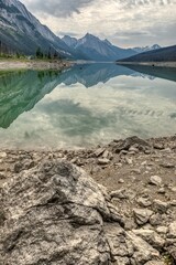 Rocky beach with perfect mountain reflection in lake - 622883228
