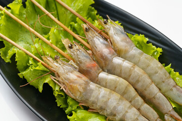 Fresh shrimp skewers on a monochrome background