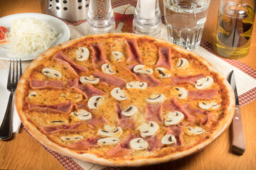 A Pizza capricciosa served with coleslaw in a restaurant