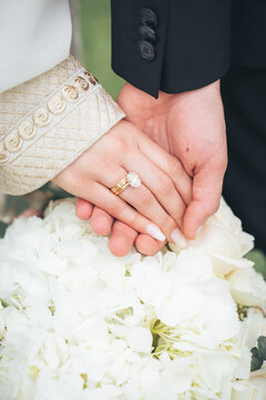 Close Up of Bride in Groom Hands with Wedding Rings and White Flowers &ndash; Muslim Wedding, Marriage Ceremony, Love, Romance, Commitment, Engagement, Bridal Jewelry, Islamic Culture, Marriage