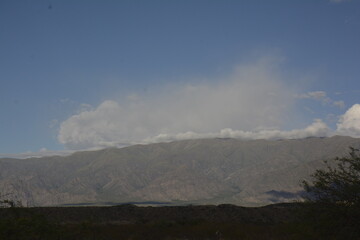 paisaje con montañas, nubes y bruma al atardecer