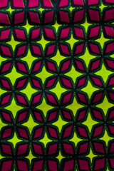 Fototapeta premium top view of pink and green ankara fabric, flatlay of nigerian wax pink and green ankara material on a table