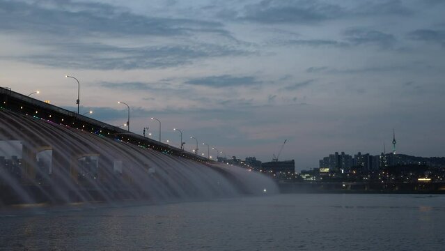 Rainbow fountain show at Banpo bridge in Seoul, South Korea Han riverside at sunset