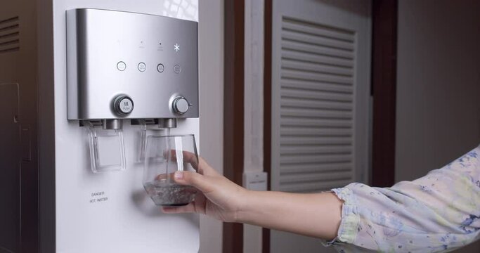 Hand-pushing cup for pure water freshness for a healthy lifestyle. Modern cooler appliance. Water filtration machine.