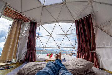 The inside of a glamping tent with man's legs in day time, Luxury camping tent for outdoor summer...