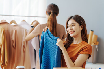 Fototapeta premium How To Start A Clothing Store Online Business apparel! Young confident asian female fashion owner social media influencer Live selling clothes, new products at home office small business e-commerce.
