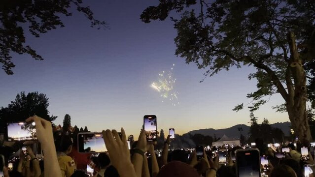 Sunset Fireworks and People, Mobile phones in hands to trying to take photos of fireworks in the park