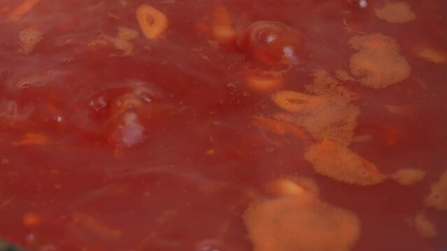 Boiling tasty and juicy red borsch, beet soup in saucepan, close up. Cooking food recipe and traditional Ukrainian dish cuisine. Domestic healthy food. Red beetroot vegetable soup, boiling in pot