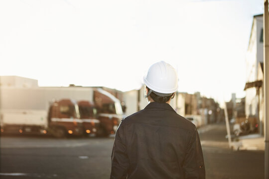 作業服とヘルメットの後ろ姿の男性