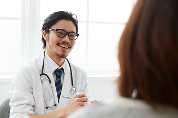問診をしている笑顔の男性医師