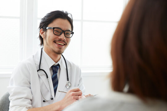 問診をしている笑顔の男性医師