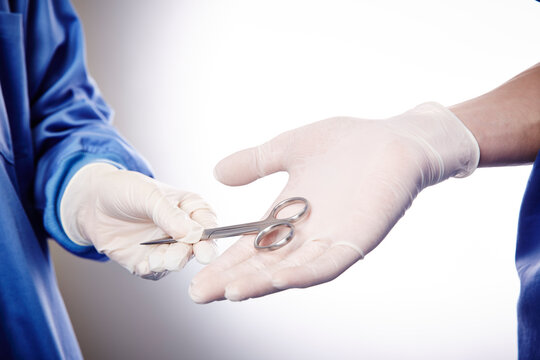 手術中の医師にハサミを渡す手元