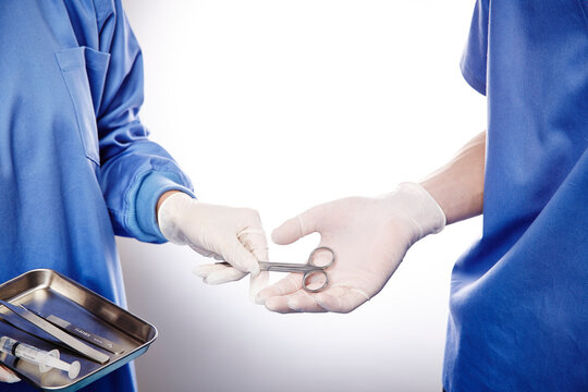 手術中の医師にハサミを渡す手元