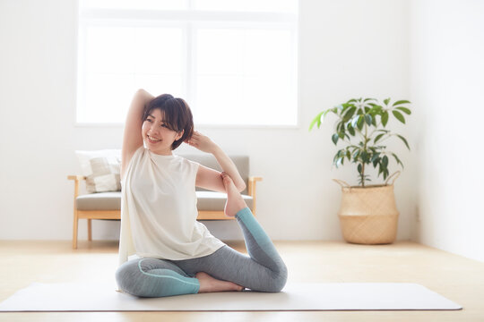 室内の床でヨガのポーズをとる女性