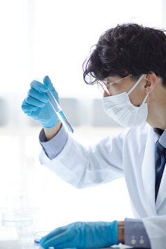 白い空間で実験をしている白衣を着た男性