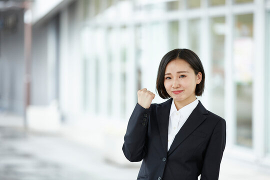 ガッツポーズして微笑むリクルートスーツの女性