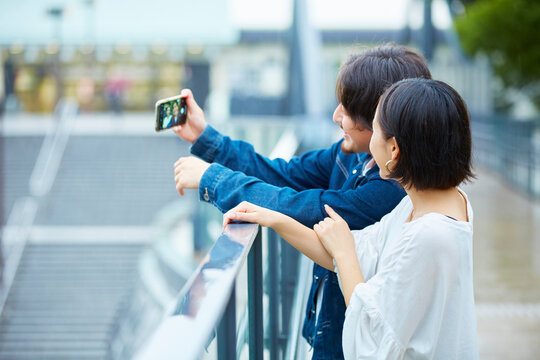 スマートフォンで自撮りをするカップル