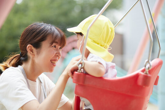 ブランコで遊ぶ子供と保育士