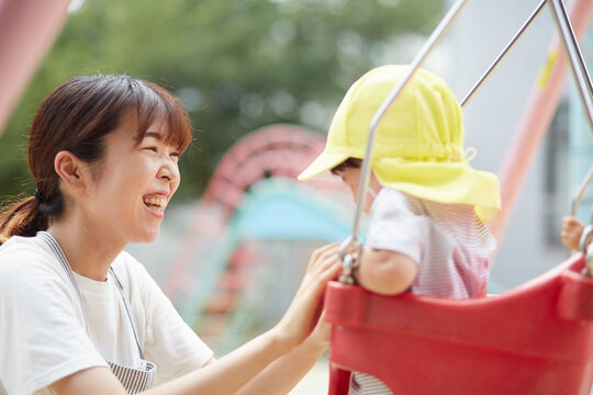 ブランコで遊ぶ子供と保育士