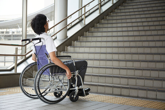 階段の前で停止する車椅子の男性