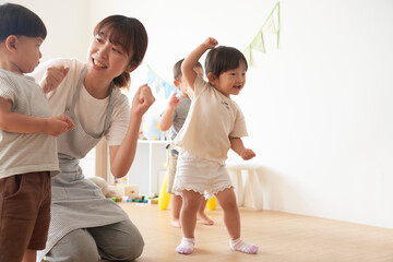 ダンスを踊る子供たちと女性の保育士