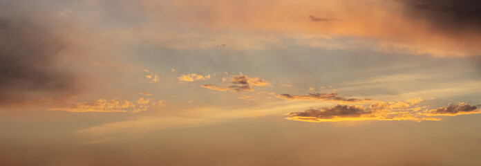 Fototapeta premium Evening sky with dark golden clouds illuminated by the sun