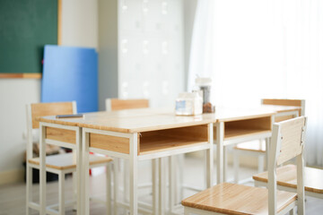Elementary classroom for kids study with teacher minimal style from Japanese furniture included wooden table, chair and chalkboard with warm color tone and soft light background