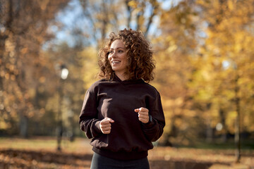 Caucasian woman jogging in the park in the autumn