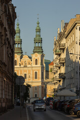 Poznan, Poland - June 12, 2023: view of Dluga street with St. Francis Seraphim church during sunset, golden hour.