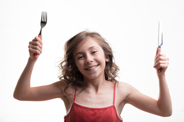 Girl eagerly holds utensils, anticipating meal