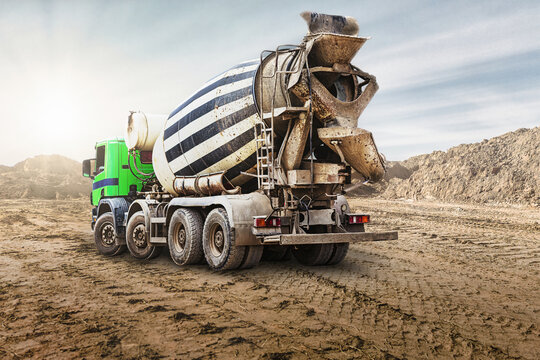 A large concrete mixer truck brought concrete to the construction site. Powerful modern machinery for construction work. Construction site. Rental of construction equipment.