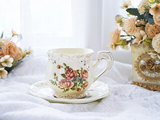 Antique cup of tea with saucer ,yellow orange rose flowers background ,porcelain vintage style ,old English coffee cup still life for wallpaper ,romance roses backgrounds 