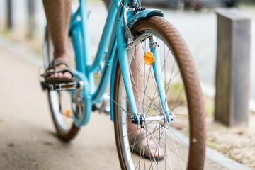 Une bicyclette bleu de côté avec un homme dessus, le vélo est neuf avec de grandes roues