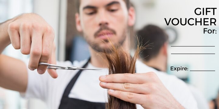 Composition of gift voucher text over caucasian male hairdresser cutting hair at hair salon