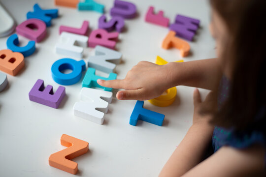 アルファベットの木のおもちゃで遊んでいる子供