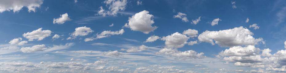Obraz premium Panoramaaufnahme des Wolkenhimmels mit zerzausten Schönwetter- und Haufenwolken vor blauem Himmel bei sonnigem Wetter