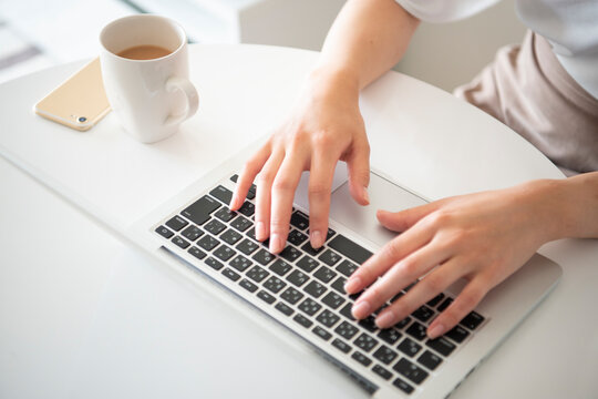 ノートパソコンで作業をしている女性の手元