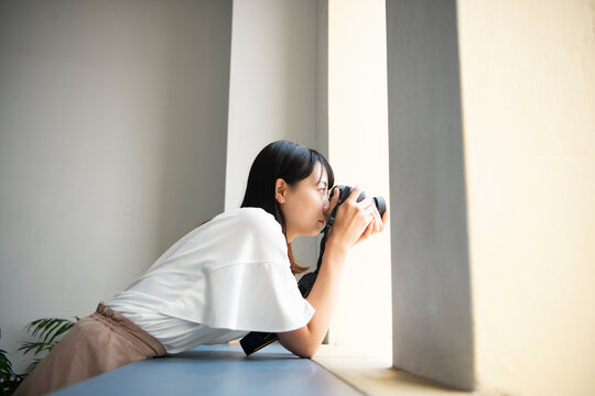 一眼レフカメラで写真を撮影している女性